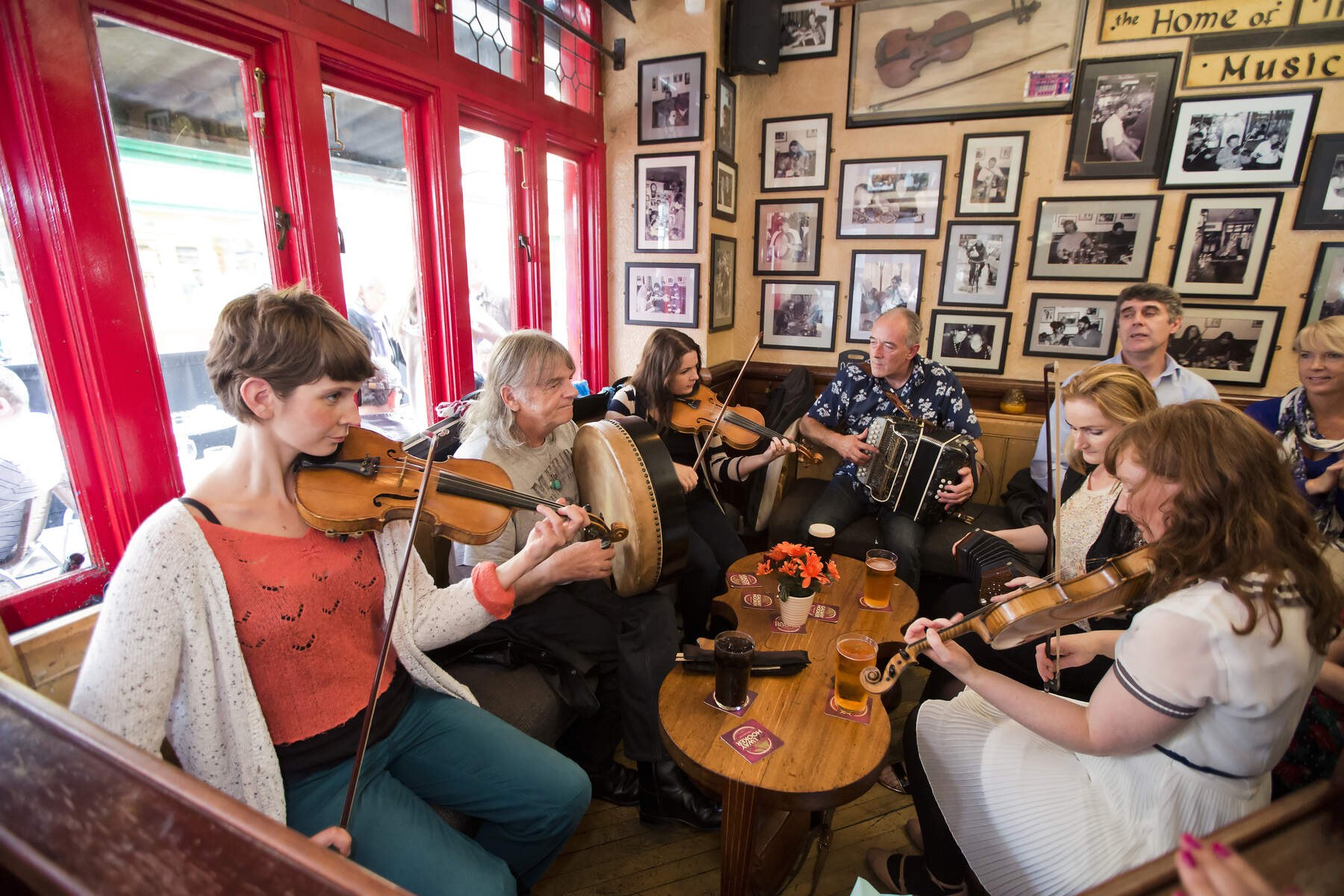 Musicians playing traditional music together in an Irish pub